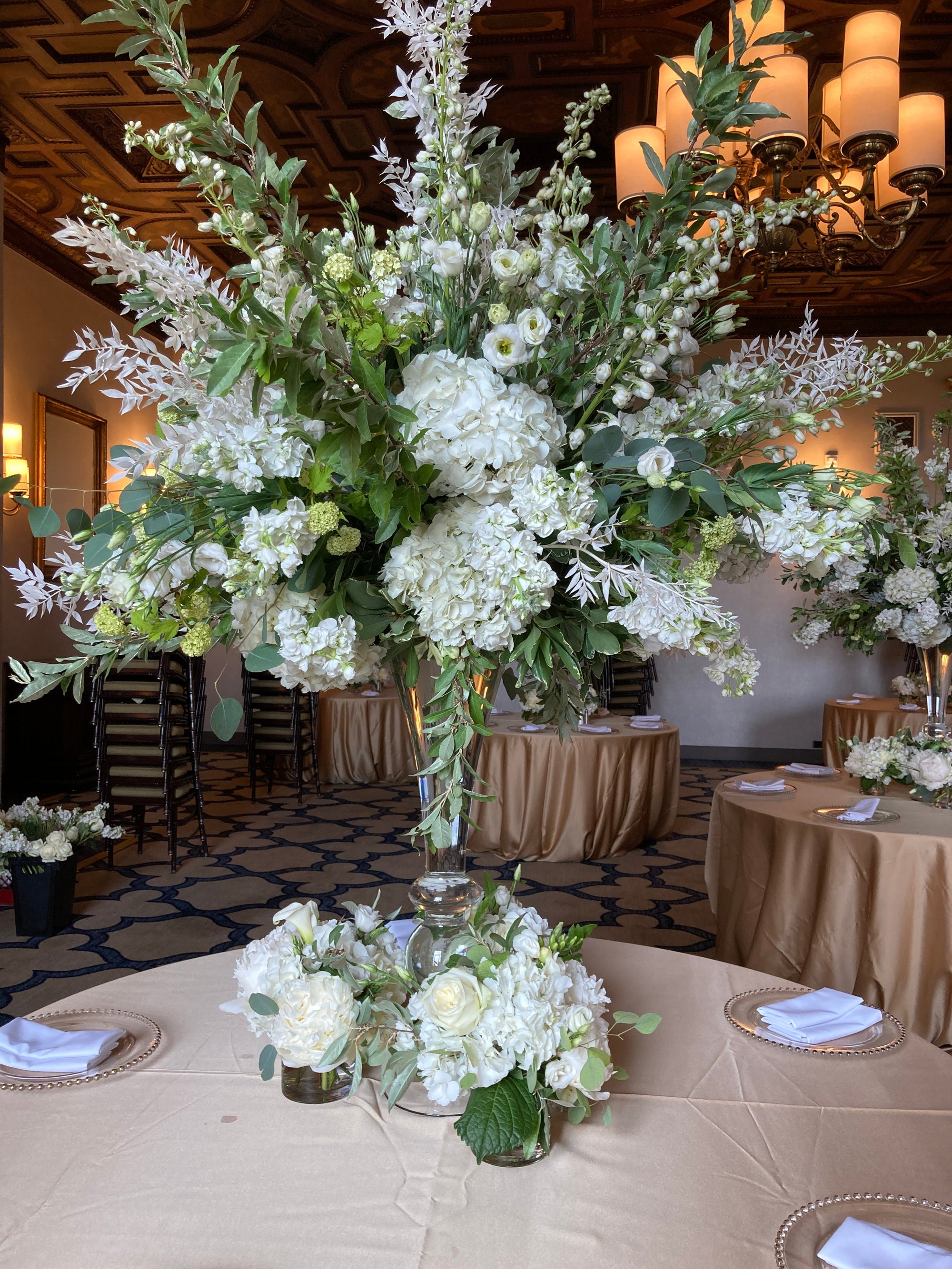 Tall white and green centerpiece arranged for a corporate reception