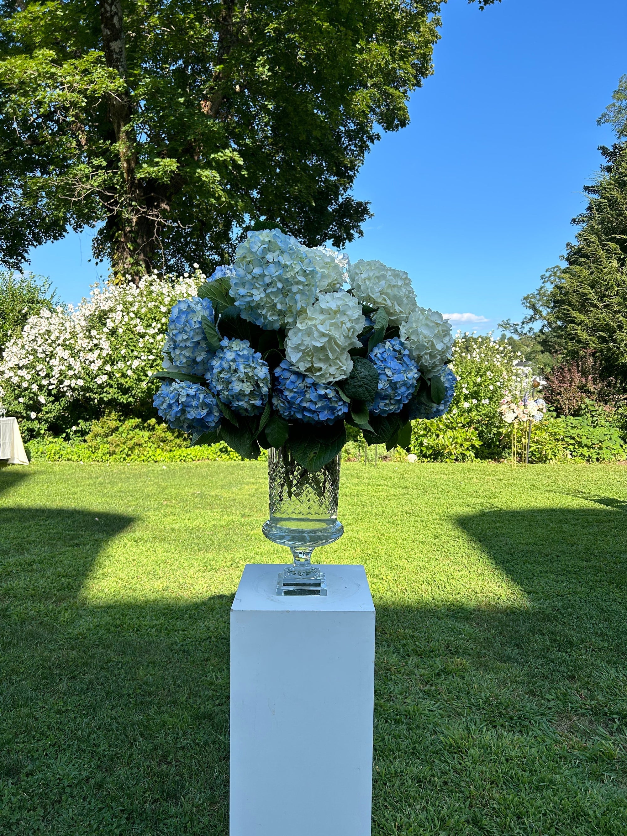 Glass urn with hydrangea ceremony arrangement at Crabtree's Kittle House, designed by Perennial Gardens