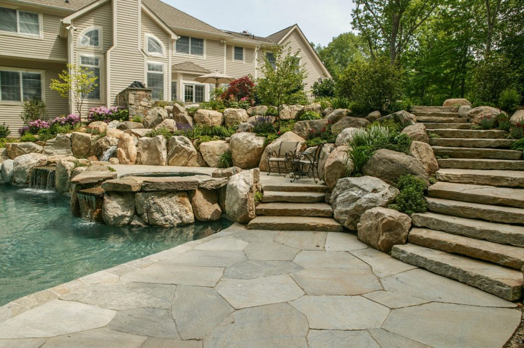 Fieldstone retaining wall with integrated pool — representative of Perennial Gardens masonry craft