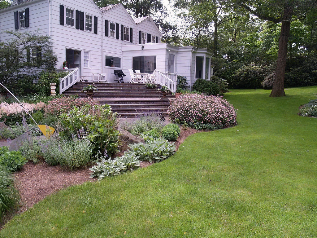 Traditional Colonial home with perennial border — representative of Chappaqua estate landscape work
