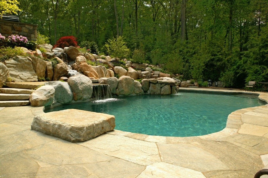 Pool with natural boulder hardscape and waterfall — representative of pool landscape work