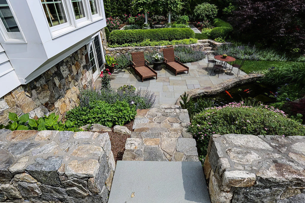 Bluestone hardscape with stone retaining walls — representative of estate driveway detail work