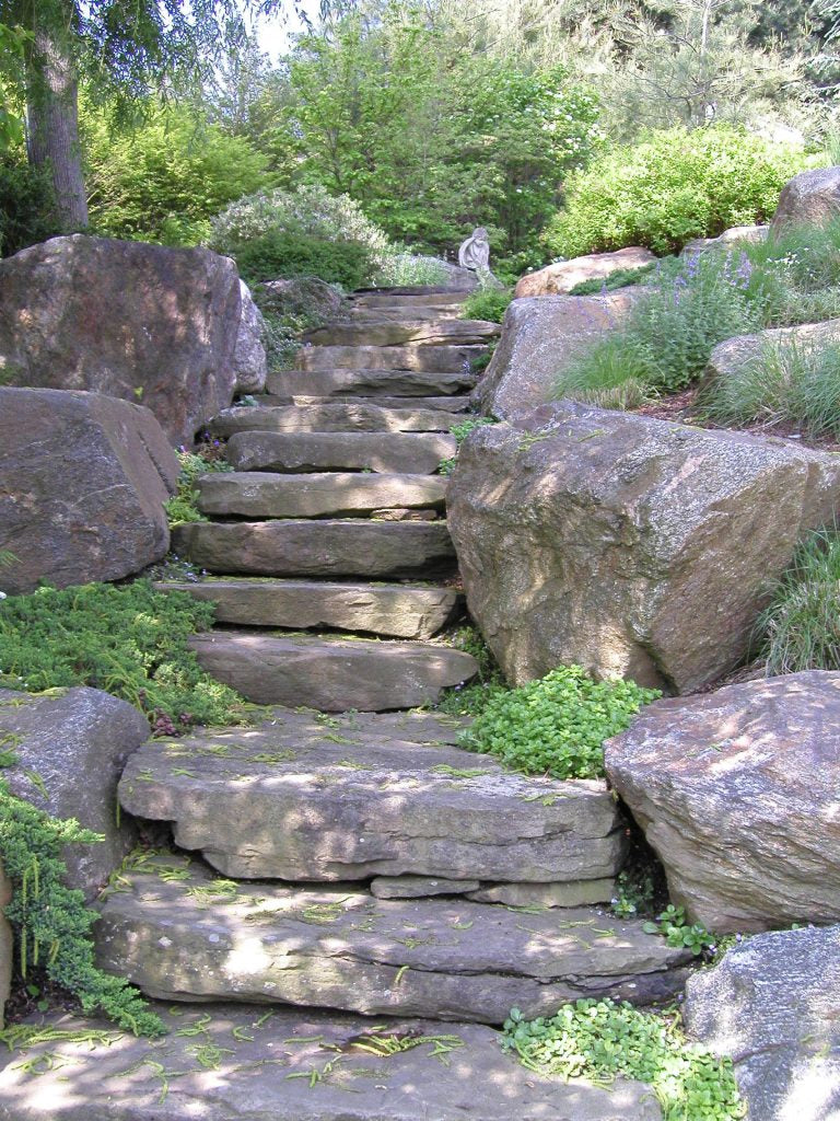 Natural stone steps winding through boulder garden — representative of hillside stonework
