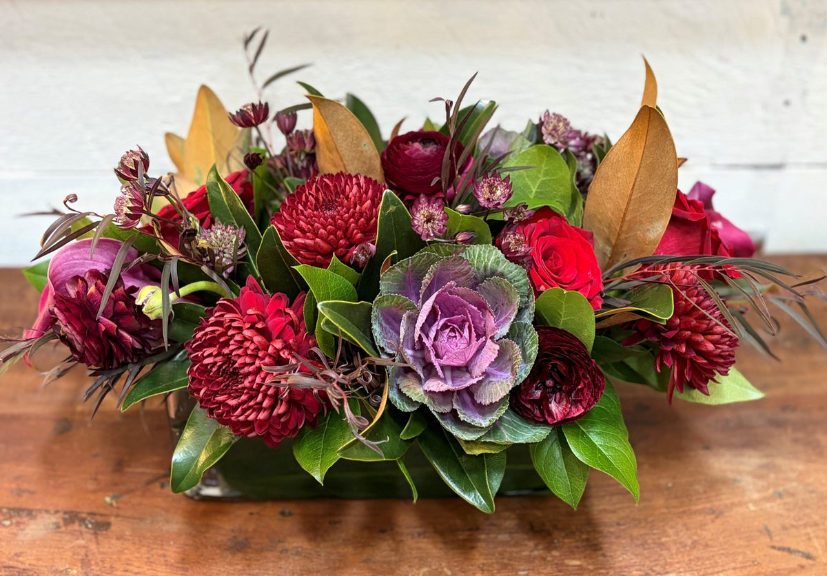 Family Gathering Thanksgiving centerpiece of crimson disbuds, purple kale and magnolia leaves, designed in Bedford