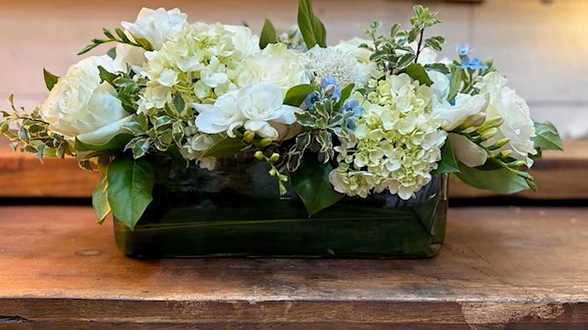 White roses, freesia and pale hydrangea in a low Rosh Hashanah centerpiece, designed at Perennial Gardens in Bedford NY